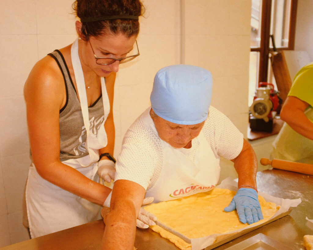 Volontarie della proloco di Vezzolacca preparano la torta di patate per la festa