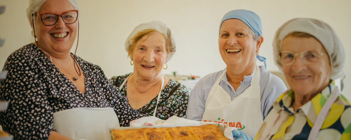 Volontarie della Proloco di Vezzolacca mostrano la torta di patate