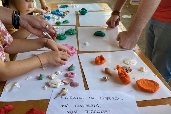 mani di bambini che formano calchi di fossili