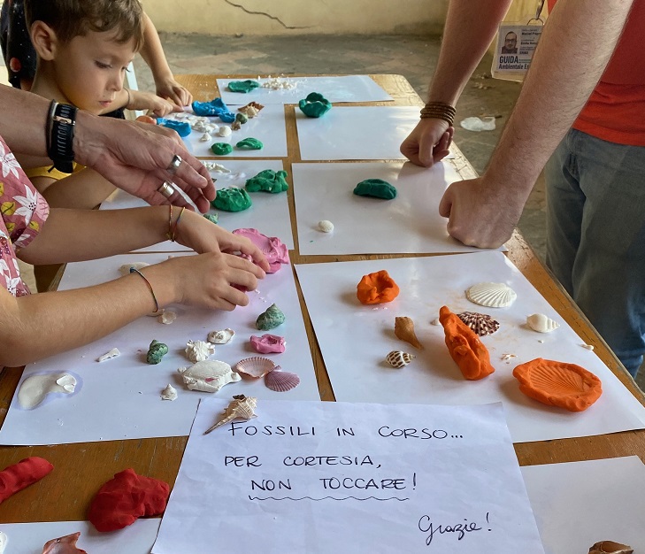 mani di bambini che formano calchi di fossili